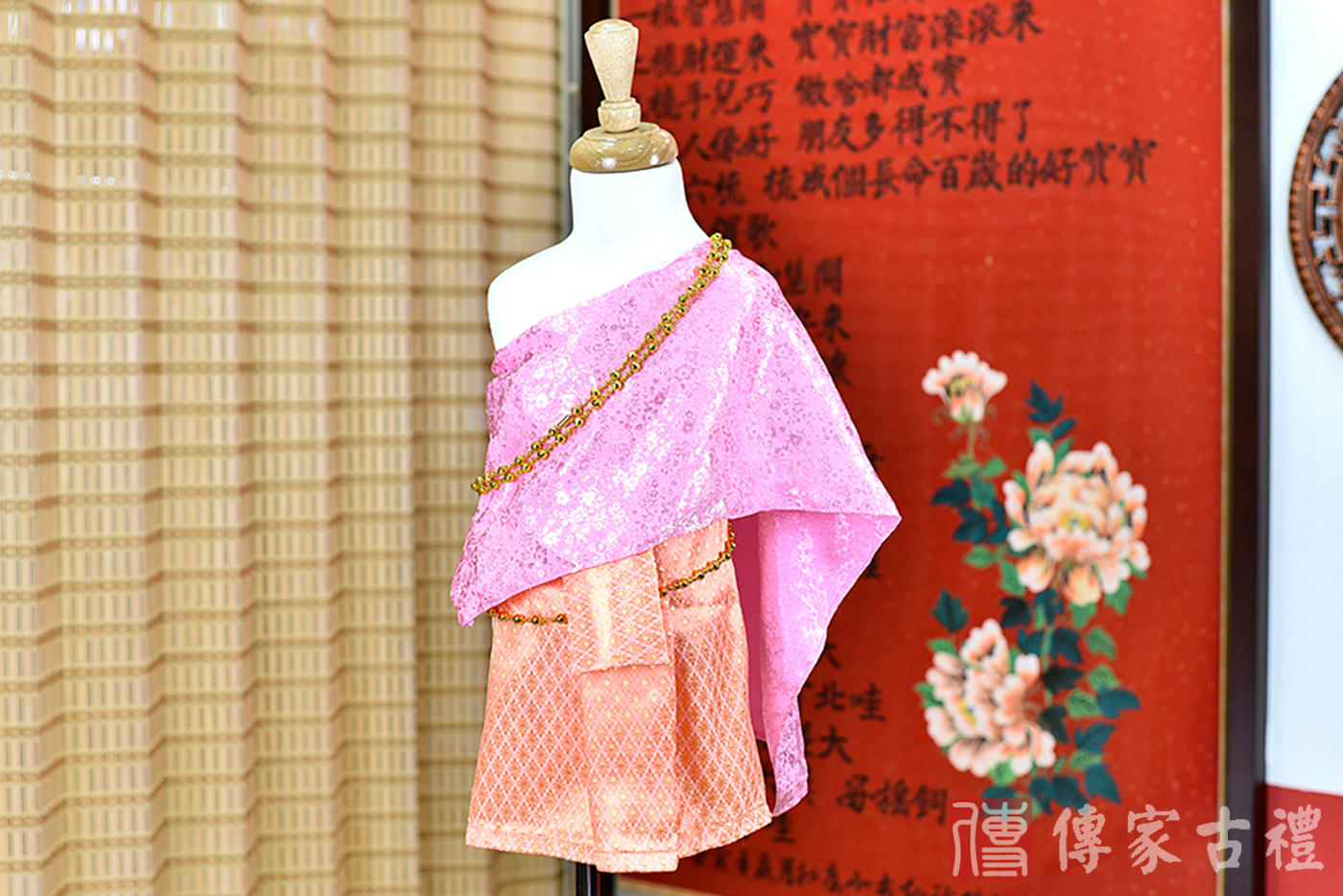 2024-02-22小孩皇室泰服古裝禮服。淺粉色的紋路披肩上衣搭配橘色小格狀裙裝的泰式古裝禮服。照片集