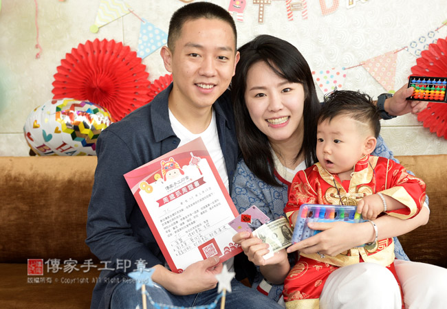 頒發抓周證書。抓周物品包含：美金、信用卡、彩色筆與算盤